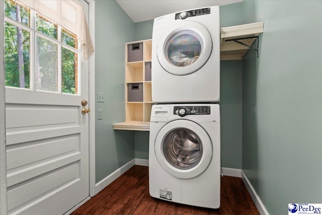 washroom featuring laundry area, stacked washer / drying machine, baseboards, and dark wood-style flooring