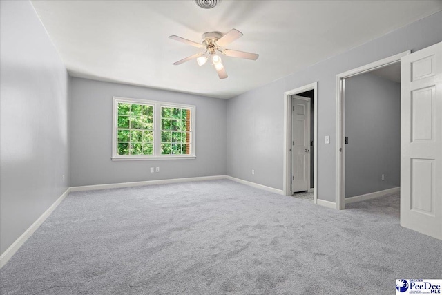 empty room with carpet, baseboards, and ceiling fan