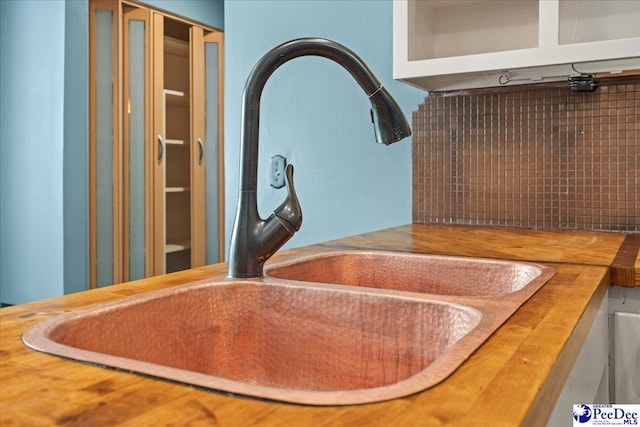 interior details with decorative backsplash and a sink