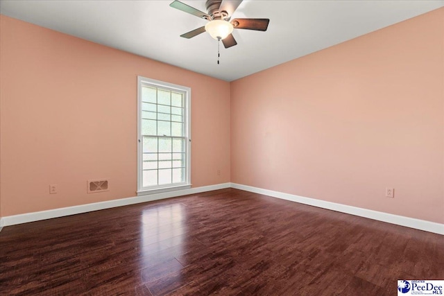 unfurnished room with dark wood-style flooring, baseboards, ceiling fan, and visible vents