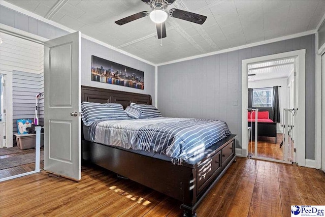 bedroom with hardwood / wood-style flooring, ornamental molding, and ceiling fan