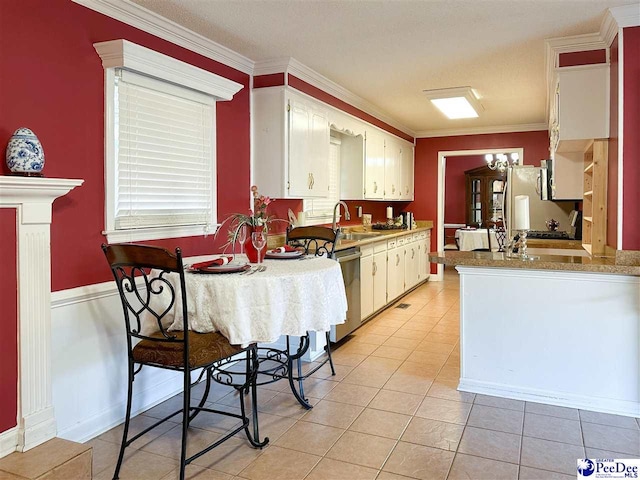 kitchen featuring sink, crown molding, appliances with stainless steel finishes, white cabinetry, and light tile patterned flooring