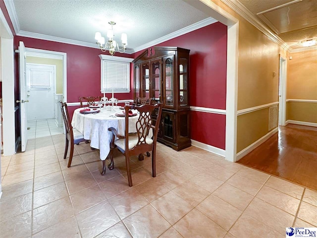 tiled dining space featuring a notable chandelier, ornamental molding, and a textured ceiling