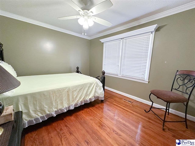 bedroom featuring crown molding, ceiling fan, and wood-type flooring