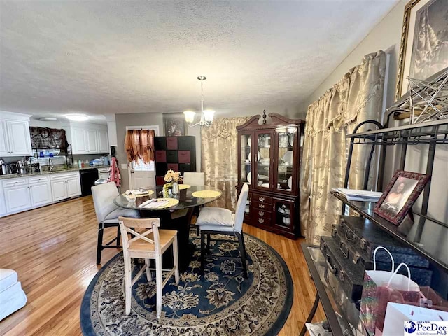 1124 N 4th Ave, Dillon, SC 29536 - dining area featuring a chandelier, light wood-type flooring, and a textured ceiling