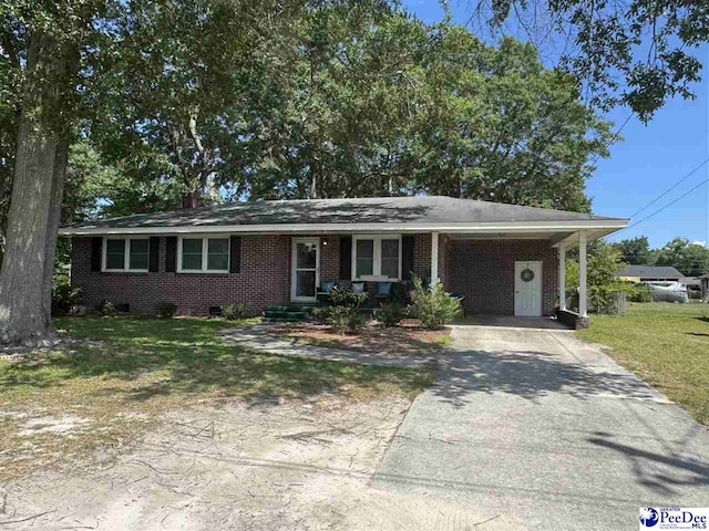 1124 N 4th Ave, Dillon, SC 29536 - ranch-style house featuring concrete driveway, brick siding, a front lawn, and an attached carport