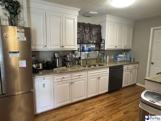 1124 N 4th Ave, Dillon, SC 29536 - kitchen featuring freestanding refrigerator, dishwasher, white cabinetry, light wood-style flooring, and a textured ceiling