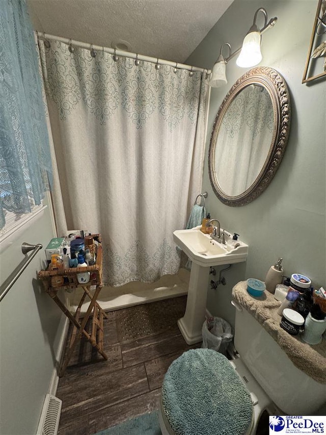 1124 N 4th Ave, Dillon, SC 29536 - bathroom with wood finished floors, a textured ceiling, and curtained shower