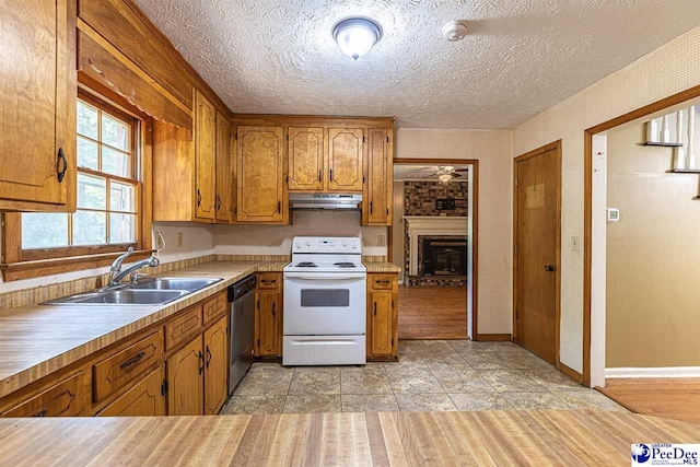 kitchen featuring a fireplace, sink, stainless steel dishwasher, white range with electric cooktop, and a textured ceiling