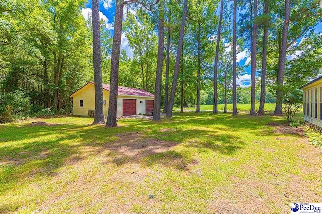 view of yard featuring a garage and an outbuilding