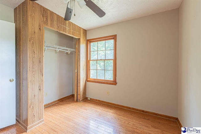 unfurnished bedroom featuring ceiling fan, light hardwood / wood-style floors, a closet, and a textured ceiling