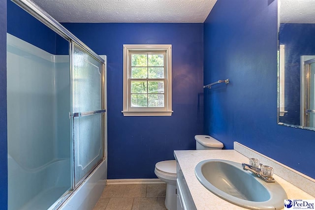 full bathroom with tile patterned flooring, vanity, a textured ceiling, and toilet