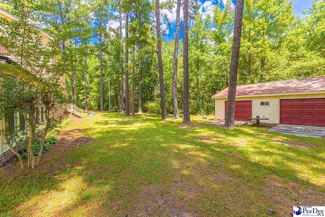 view of yard with a garage and an outdoor structure