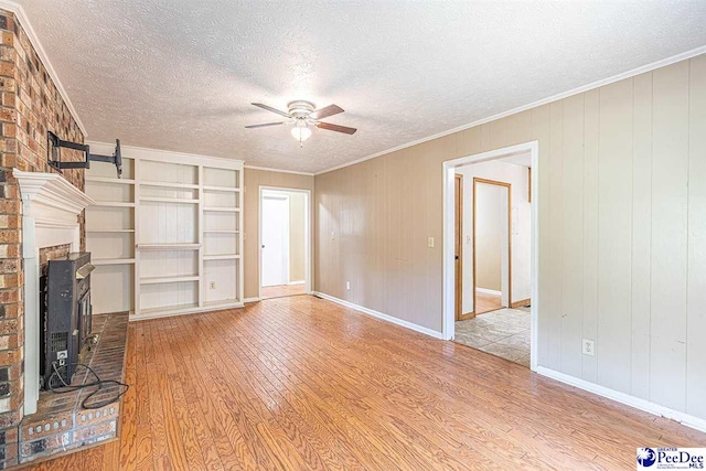 unfurnished living room featuring crown molding, ceiling fan, a textured ceiling, and light hardwood / wood-style floors