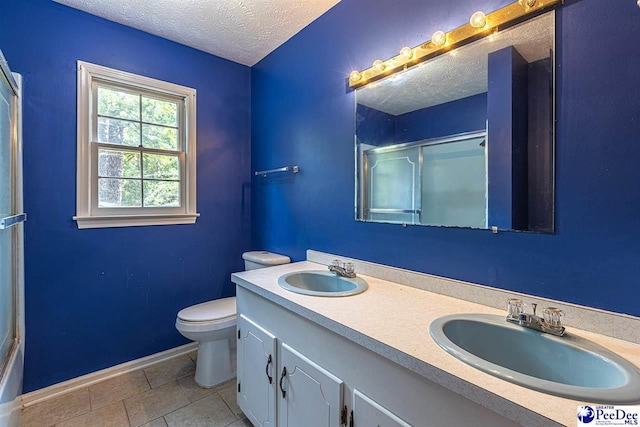 bathroom with vanity, an enclosed shower, a textured ceiling, and toilet