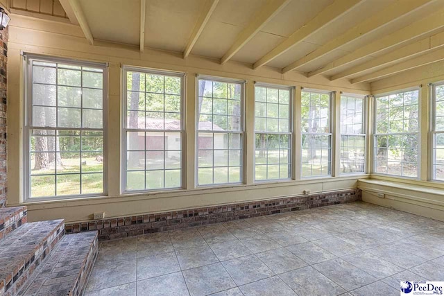 unfurnished sunroom with a healthy amount of sunlight and beam ceiling