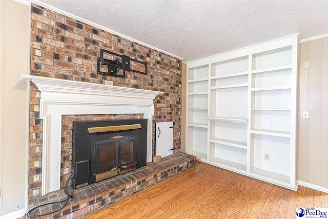 unfurnished living room with wood-type flooring, built in features, and a textured ceiling