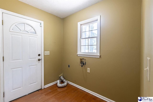 laundry area with hookup for a washing machine, hardwood / wood-style floors, hookup for an electric dryer, and a textured ceiling