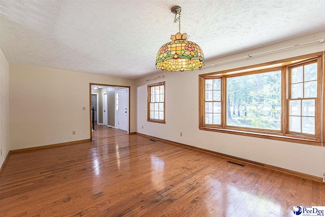 empty room featuring hardwood / wood-style flooring and a textured ceiling