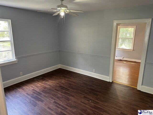 unfurnished room with ceiling fan and dark hardwood / wood-style flooring