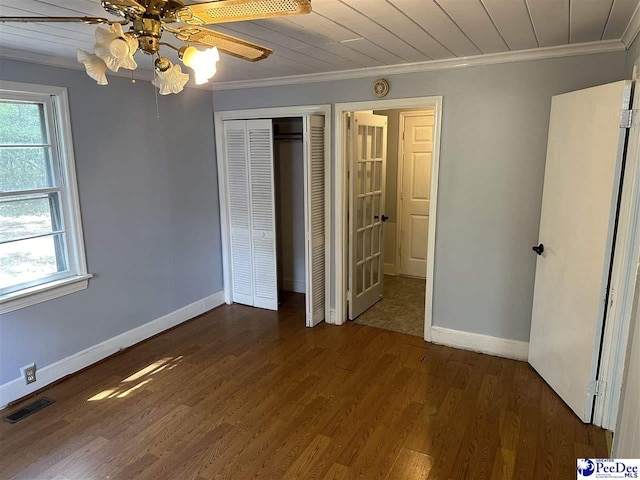 unfurnished bedroom featuring ornamental molding, dark hardwood / wood-style flooring, and multiple windows