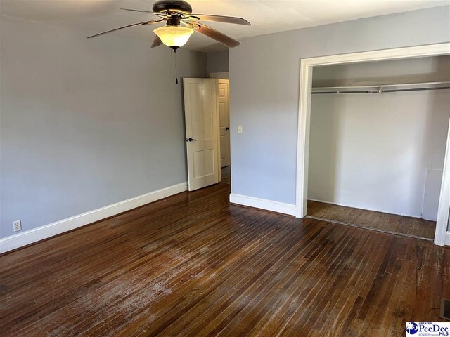 unfurnished bedroom featuring dark hardwood / wood-style flooring, a closet, and ceiling fan