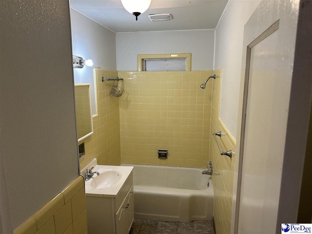 bathroom featuring vanity, tiled shower / bath combo, and tile patterned flooring