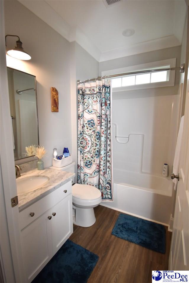 3804 Beckford St, Florence, SC 29501 - full bathroom with vanity, toilet, shower / bath combination with curtain, and wood finished floors