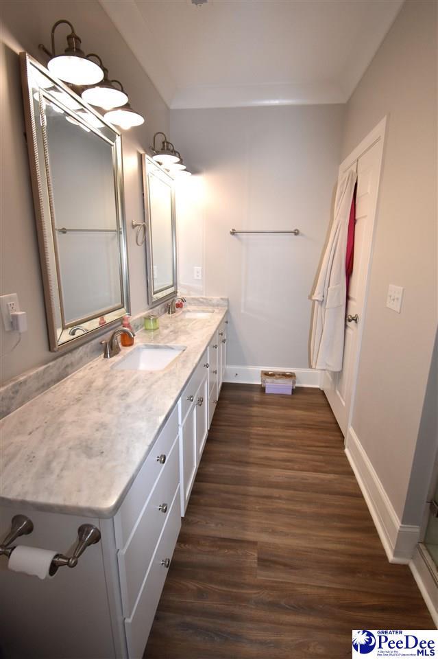 3804 Beckford St, Florence, SC 29501 - bathroom with wood finished floors, double vanity, baseboards, and crown molding