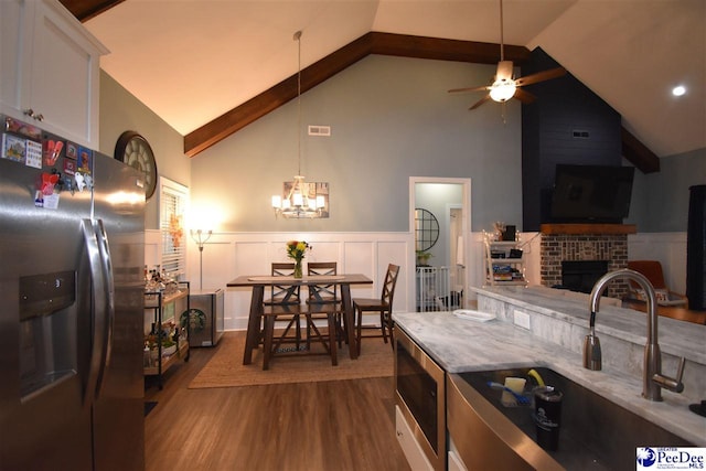 3804 Beckford St, Florence, SC 29501 - kitchen with appliances with stainless steel finishes, a sink, high vaulted ceiling, a wainscoted wall, and dark wood finished floors