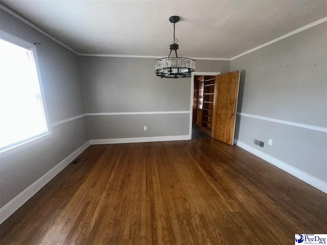 unfurnished dining area featuring crown molding, dark wood-type flooring, and a notable chandelier