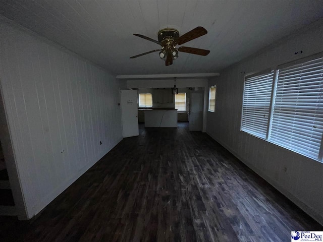 unfurnished living room with dark hardwood / wood-style floors and ceiling fan