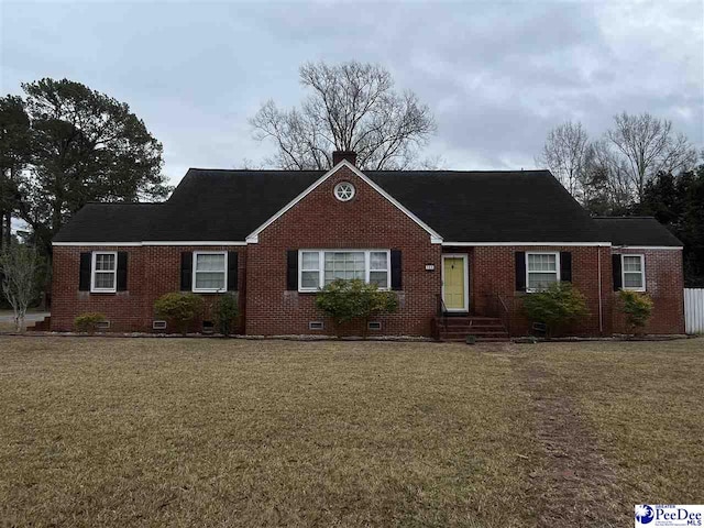 view of front of property with brick siding, crawl space, and a front lawn