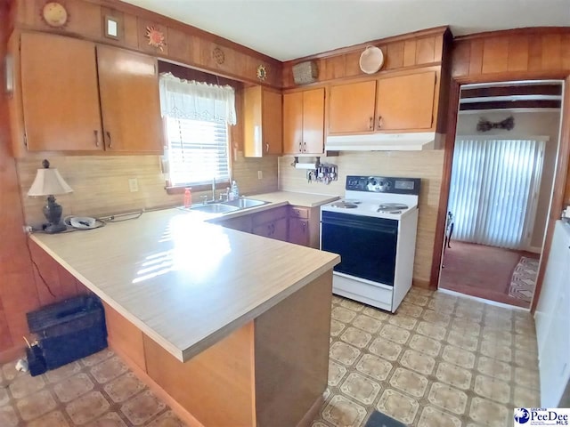 kitchen featuring electric stove, sink, tasteful backsplash, and kitchen peninsula