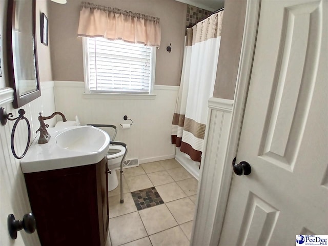 bathroom featuring a shower with shower curtain, vanity, toilet, and tile patterned flooring