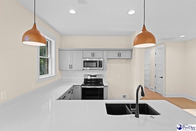 125 E Pine St, Florence, SC 29506 - kitchen with stainless steel appliances, gray cabinets, light countertops, hanging light fixtures, and recessed lighting