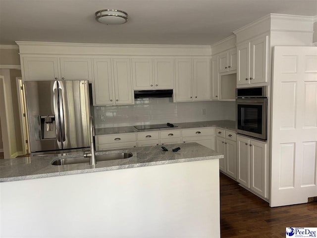 kitchen with dark wood-style floors, light stone countertops, stainless steel appliances, under cabinet range hood, and tasteful backsplash