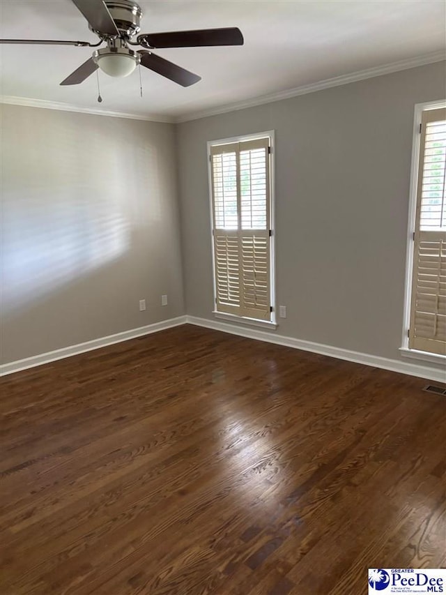 empty room featuring dark wood finished floors, visible vents, a ceiling fan, and crown molding
