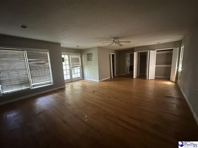 unfurnished living room featuring baseboards, ceiling fan, and wood finished floors