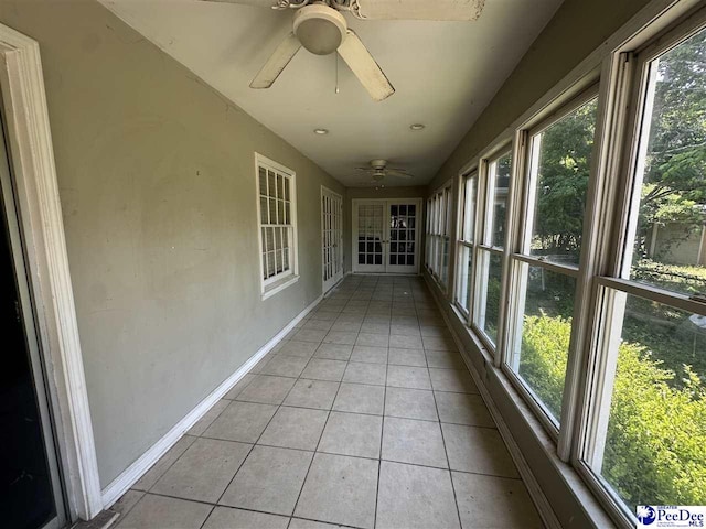 unfurnished sunroom with baseboards, french doors, and tile patterned flooring