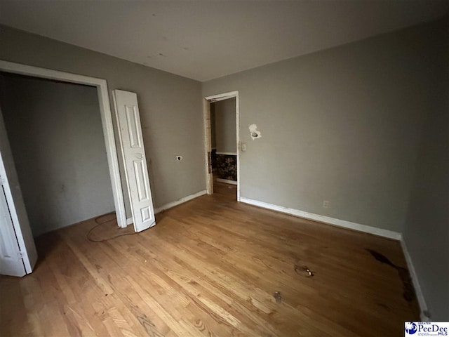 unfurnished bedroom featuring light wood-style floors and baseboards