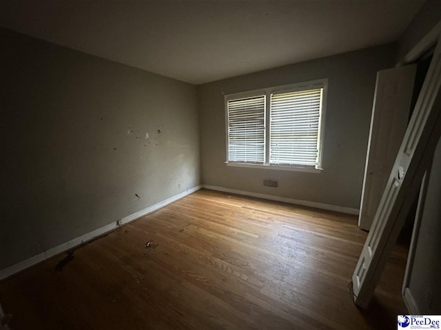 unfurnished bedroom with baseboards and wood finished floors