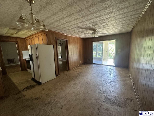 interior space featuring wooden walls, an ornate ceiling, a ceiling fan, and visible vents