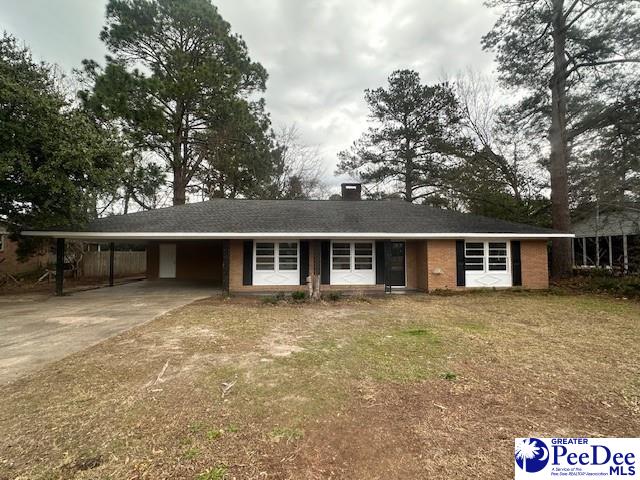 ranch-style house with a front lawn and a carport