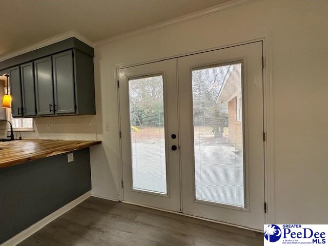 doorway with hardwood / wood-style floors, french doors, and crown molding