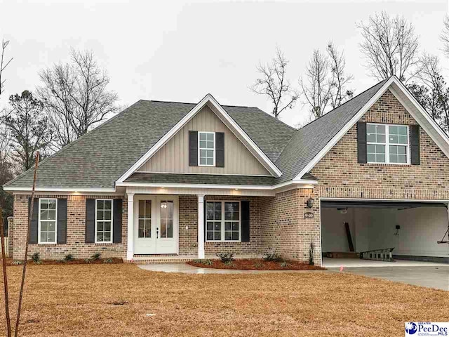 view of front of house featuring a garage, a front lawn, and french doors