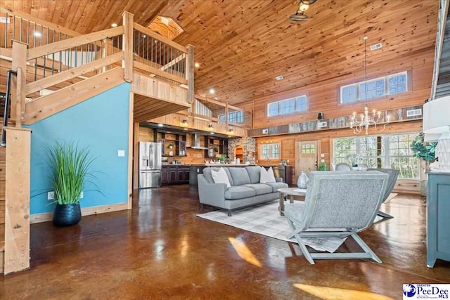 living room featuring a notable chandelier, finished concrete flooring, a high ceiling, wood ceiling, and baseboards