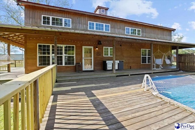 back of house with fence and a wooden deck