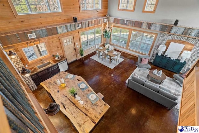 living room featuring wooden walls, visible vents, and a towering ceiling