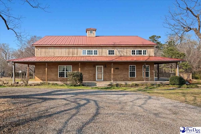 back of property with covered porch and metal roof